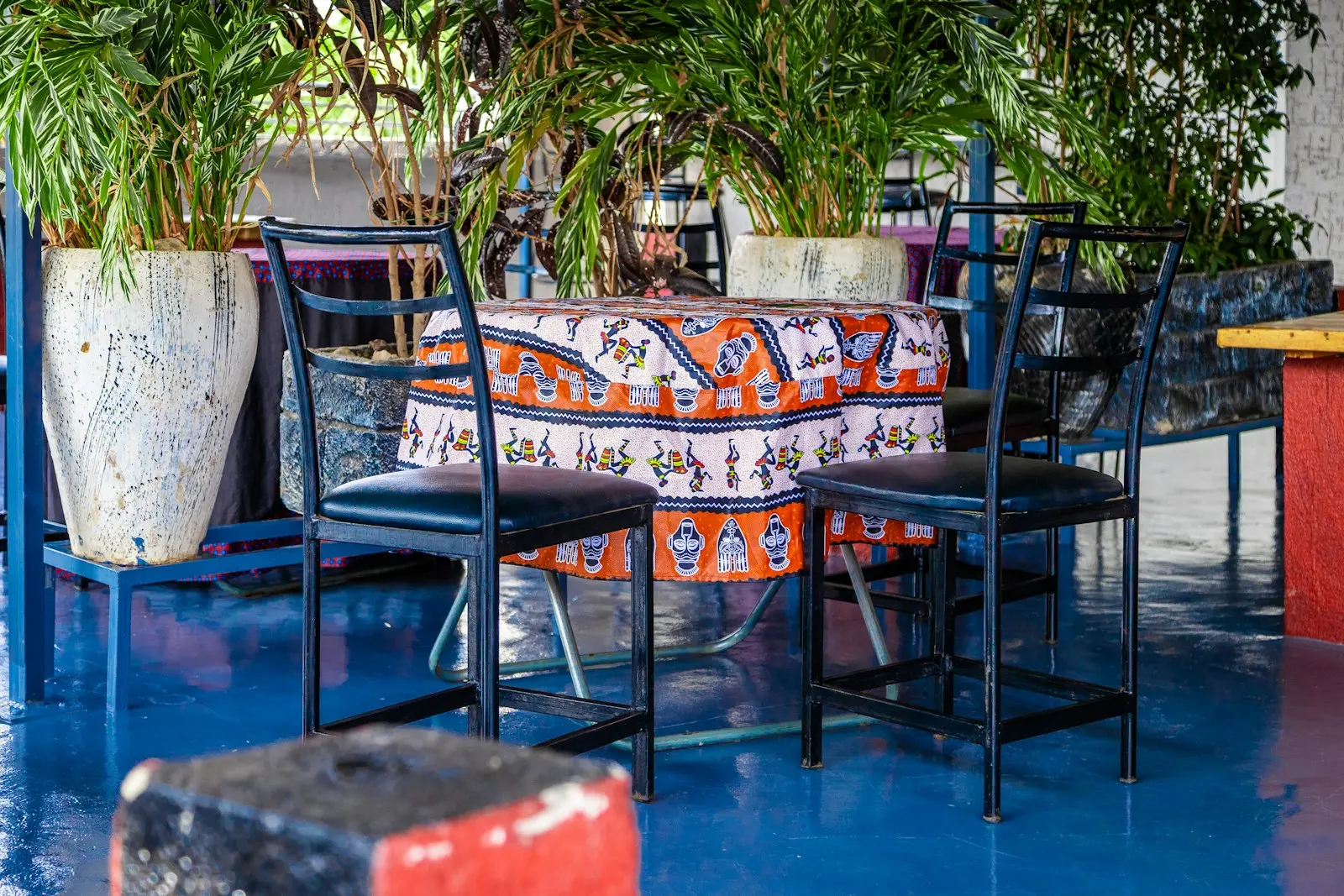 A colourful restaurant courtyard with a printed tablecloth